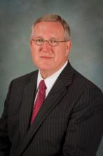 Van Horne - Member. Man with glasses in gray suit with red tie