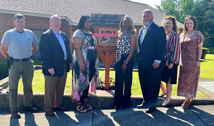 Group standing outside in front of new book nook