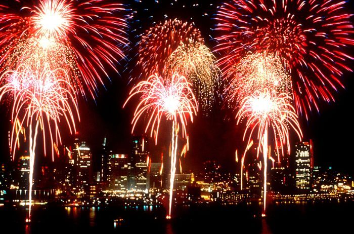 Several fireworks exploding over a cityscape.